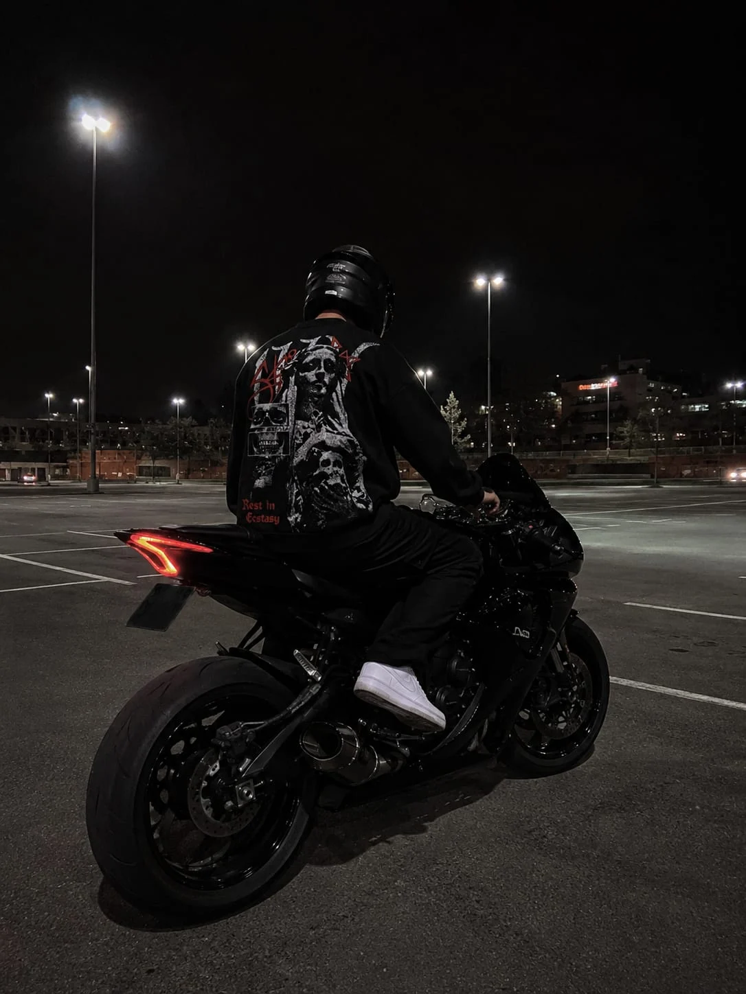 Pull noir porté à moto, vue de dos