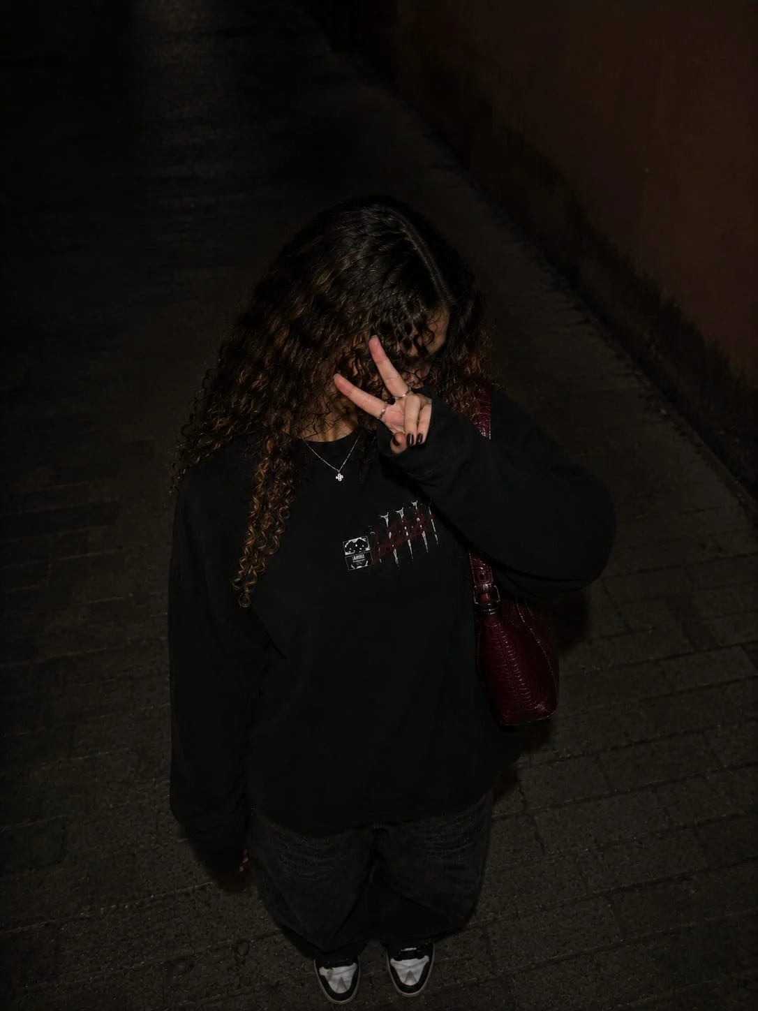 Pull noir porté de face, de nuit